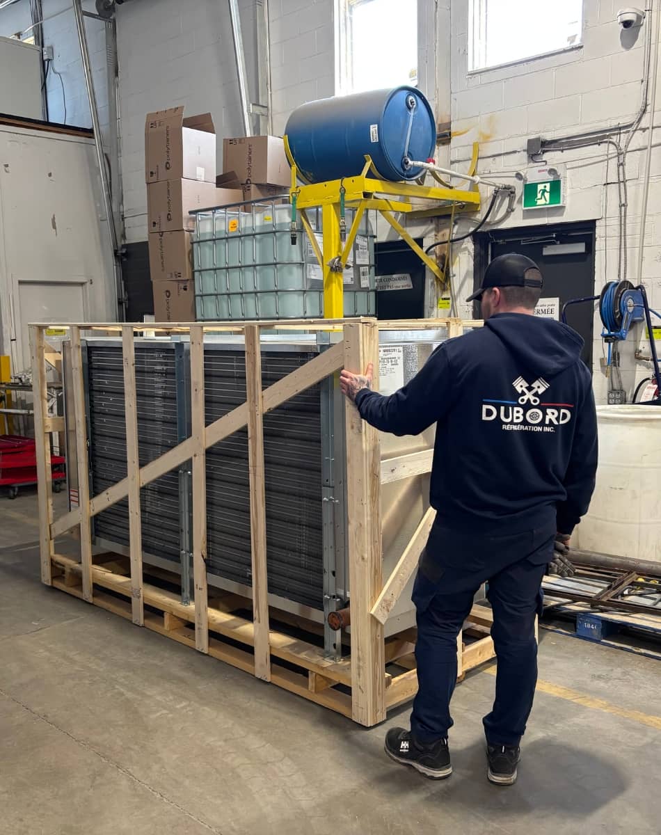 Entrepreneur en réfrigération de dos dans un entrepôt.